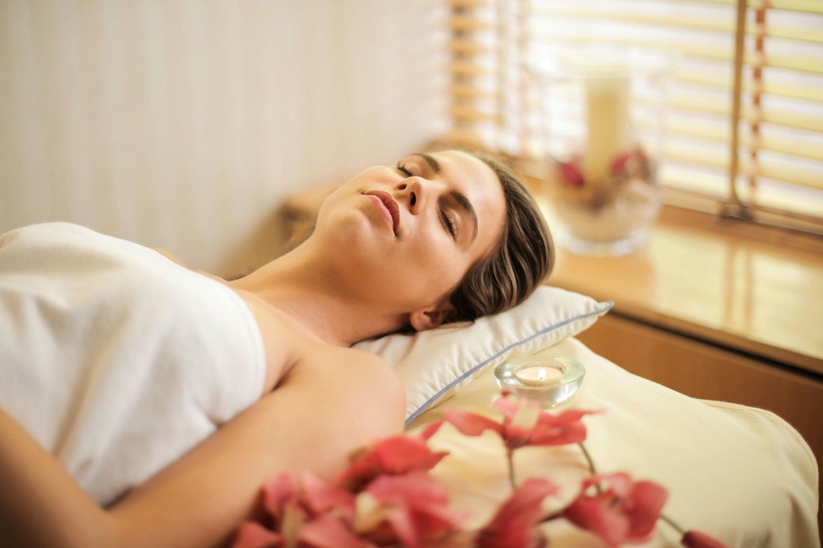 woman-relaxing-during-spa-treatment-with-candle-and-flowers